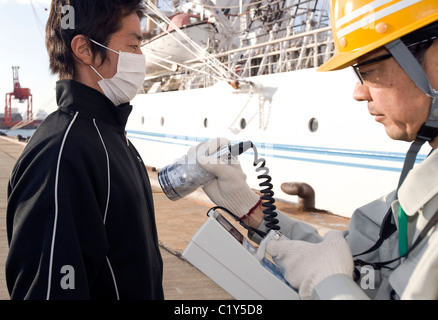 Mitglied der so genannten Fukushima 50 ist einen Strahlung Check vor dem Einstieg in die Kaiwomaru gegeben. Stockfoto