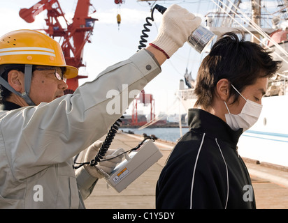 Mitglied der so genannten Fukushima 50 ist einen Strahlung Check vor dem Einstieg in die Kaiwomaru gegeben. Stockfoto