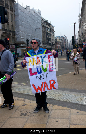 Junger Mann mit Liebe nicht machen Krieg Zeichen in Piccadilly vor März für die Alternative Rallye organisiert von der TUC, London, England Stockfoto