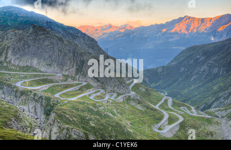 Alte Straße mit engen Serpentinen auf der Südseite des St. Gotthardpasses Überbrückung Schweizer Alpen bei Sonnenuntergang Stockfoto