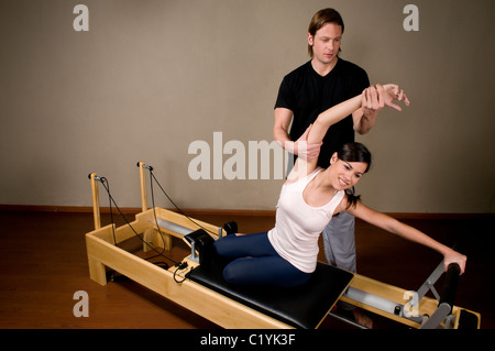 Bild, eine, Frau, Frau, legen, liegen, erweitern, erweitern, dehnen, stretching, ihr Bein, Beine, auf einem schwarzen, Matten, Matratzen. Stockfoto