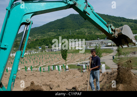 Mann gräbt neue Gräber auf dem Srebrenica Potocari Genozid-Denkmal und Friedhof für die Opfer des Genozids 1995 in der Republika Srpska, einem Gebilde von Bosnien und Herzegowina. Mehr als 8,000 bosnisch-muslimische Männer und Jungen wurden getötet, nachdem die serbische Armee am 10-11. Juli 1995 trotz der Anwesenheit von UN-Friedenstruppen Srebrenica, ein ausgewiesenes UN-Sicherheitsgebiet, angegriffen hatte. Stockfoto