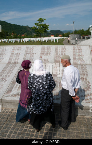 Bosniaken lesen Namenswand am Srebrenica Potocari Genozid-Denkmal und Friedhof für die Opfer des 1995 Genozids im östlichsten Teil der Republika Srpska, einer Einheit von Bosnien und Herzegowina. Mehr als 8,000 bosnisch-muslimische Männer und Jungen wurden getötet, nachdem die serbische Armee am 10-11. Juli 1995 trotz der Anwesenheit von UN-Friedenstruppen Srebrenica, ein ausgewiesenes UN-Sicherheitsgebiet, angegriffen hatte. Stockfoto