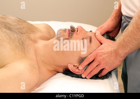 Schwedische Massage Therapie Gesicht eines Mannes in einem Spa entspannen. Ältere Kerl aufgedeckt auf Tisch Masseur in einem Day Spa eine entspannende Gesichtsmassage erhalten. Stockfoto