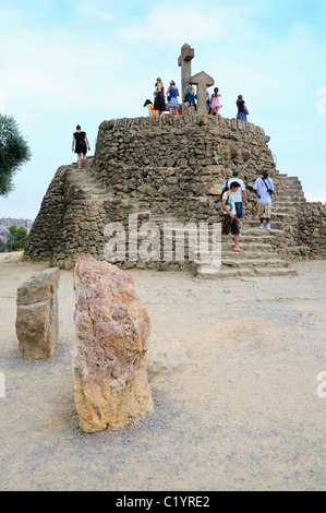 Die Tortur (Steinhügel) mit der Calvary (Turó de Les Tres Creus, drei Kreuze), Parc Güell, Barcelona, Spanien. Stockfoto