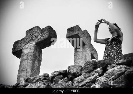 Eine Frau, die ein Bild an der Spitze der Tortur (Steinhügel), die höchste Stelle im Parc Güell, Barcelona, Spanien. Stockfoto