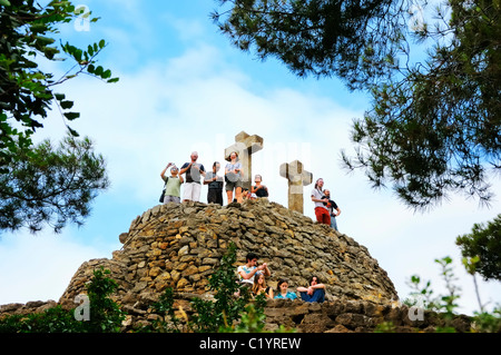 Die Tortur (Steinhügel) mit der Calvary (Turó de Les Tres Creus, drei Kreuze), Parc Güell, Barcelona, Spanien. Stockfoto