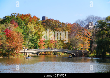 New York City Central Park Panoramablick im Herbst mit Manhattan Wolkenkratzer und bunten Bäumen Regenbogenbrücke über See w Stockfoto