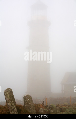 Alte licht Leuchtturm durch dichten Nebel mit Grabsteine im Beacon Hill Friedhof im Vordergrund auf Lundy Island, Devon, England UK im März umgeben Stockfoto