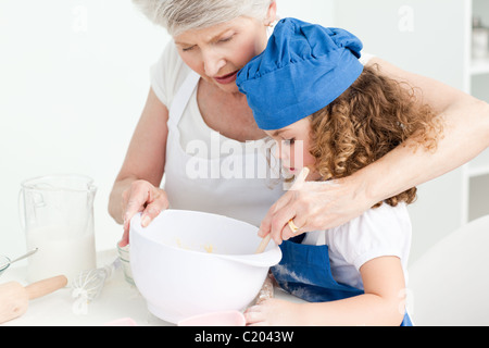 Ein kleines Mädchen mit ihrer Großmutter Backen Stockfoto