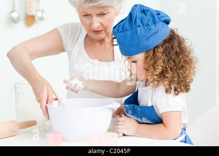 Ein kleines Mädchen mit ihrer Großmutter Backen Stockfoto