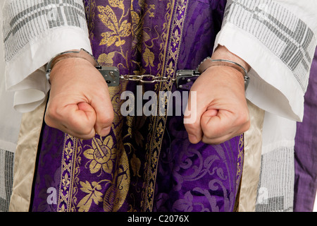 Missbrauch in der Kirche. Pfr. in Handschellen Stockfoto