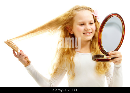 Porträt eines blonden Mädchens Bürsten Haare vor dem Spiegel Stockfoto