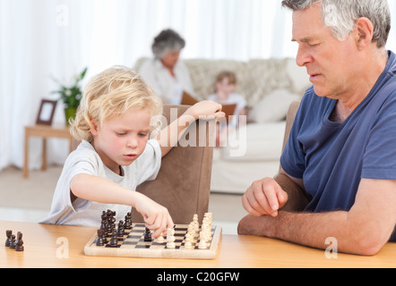 Kleiner Junge spielt Schach mit seinem Großvater Stockfoto