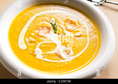 frischer Kürbis und Garnelen-Creme-Suppe mit Sahne obendrauf Stockfoto