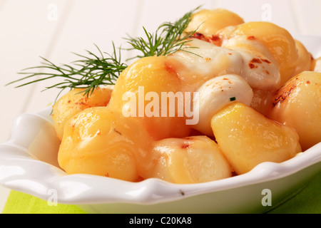 Schüssel mit Pfanne Bratkartoffeln garniert mit Käse überbacken Stockfoto