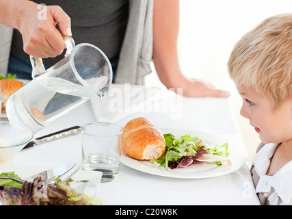 Großmutter ihren Enkel etwas Wasser zu geben, während des Essens Stockfoto
