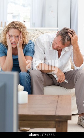 Liebhaber, die vor dem Fernseher im Wohnzimmer zu Hause Stockfoto