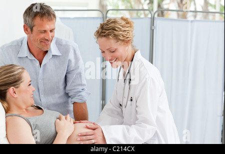 Schwangere Frau mit ihrem Ehemann die Krankenschwester anhören Stockfoto