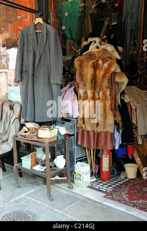 Alte oder Vintage Kleidung einschließlich Pelz Stücke hängen vor einem Geschäft direkt an der Kapelle Markt Islington London England UK Stockfoto