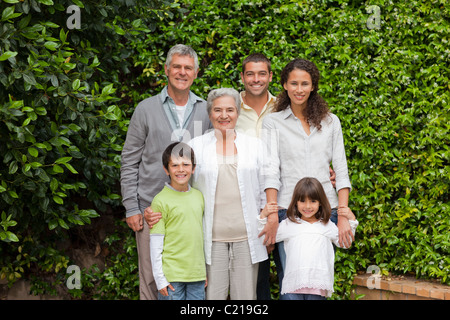 Porträt einer glücklichen Familie schaut in die Kamera im Garten Stockfoto