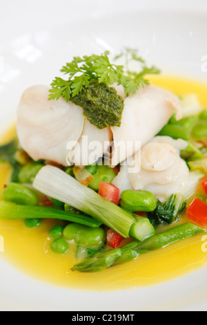 Seeteufel auf einem Bett aus grünem Gemüse mit Beurre Blanc Sauce gedünstet. Stockfoto