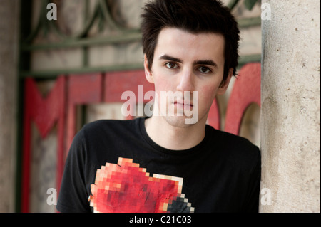 Dunkel und hübscher junger Mann trug ein schwarzes T-shirt mit floralem Design. Stockfoto