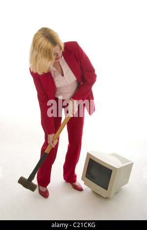 Frustrierte Frau etwa, Monitor mit Vorschlaghammer zu zerschlagen. Stockfoto