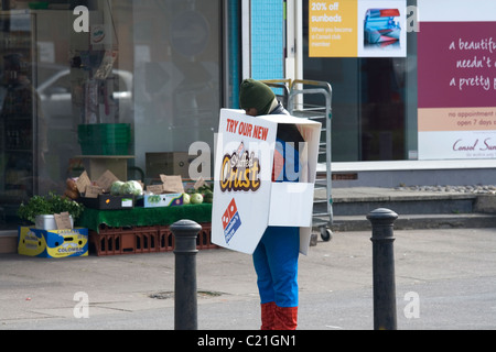 Ein Sandwich Board Mann verkleidet in einem Spiderman-Kostüm Stockfoto