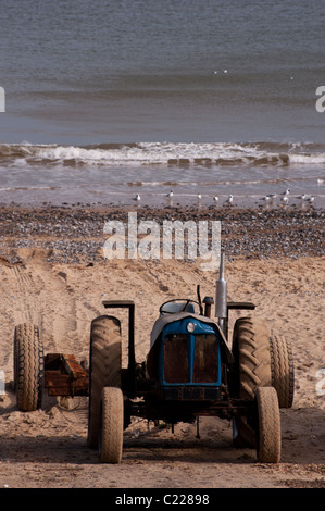 Einen alten Traktor am Cromer Strand wo Traktoren verwendet werden, um die Fischerboote aus dem Sand zu starten. Stockfoto