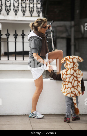 Emily Maitlis macht einige stretching, wie nimmt sie ihren Sohn Sohn Milo Atticus gekleidet wie eine Giraffe nach Schule London- Stockfoto