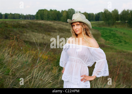 Schöne junge Frau zu Fuß in ein Feld. Stockfoto