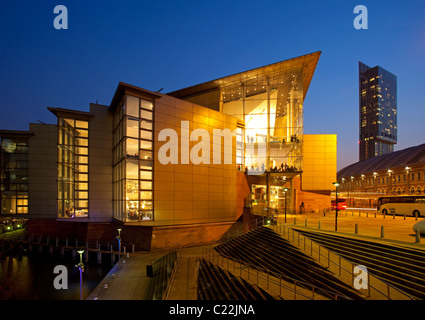 England, Manchester, Bridgewater Hall in der Dämmerung mit Blick in Richtung Beetham Tower beleuchtet Stockfoto