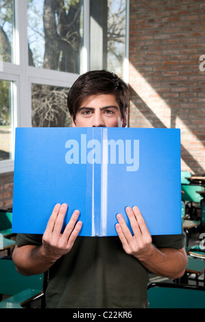 Erwachsener, Mann, Mann, Blick auf, die Kamera hält, einen, blau, Ordner, im Klassenzimmer, Campus, Universität, Klasse. Stockfoto