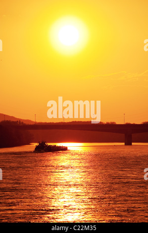 Push-Boot mit Ladung Segeln in Richtung Sonnenuntergang an der Donau in Bratislava Stockfoto