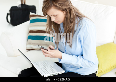 Junge Geschäftsfrau mit Laptop und Handy Stockfoto