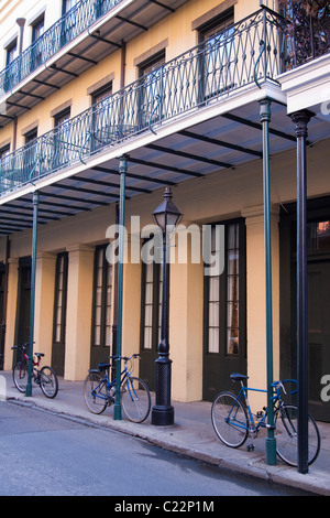 Drei Fahrräder angebracht zu den Polen auf attraktiven Gebäude in Chartres Street im French Quarter von New Orleans Stockfoto