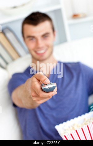 Positiven kaukasischen Mann hält einen entfernten Blick auf die Kamera in das Wohnzimmer Stockfoto