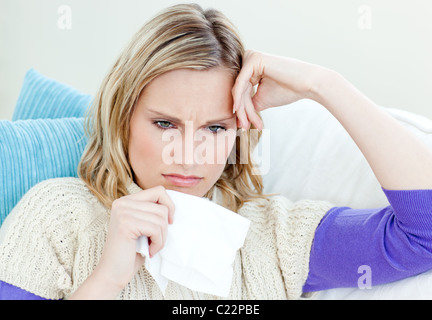 Kranke Frau auf einem Sofa liegend mit Gewebe Stockfoto