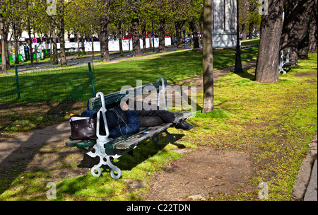 Obdachloser auf einer Parkbank schlafen; Paris, Frankreich, Europa. Charles Lupica Stockfoto