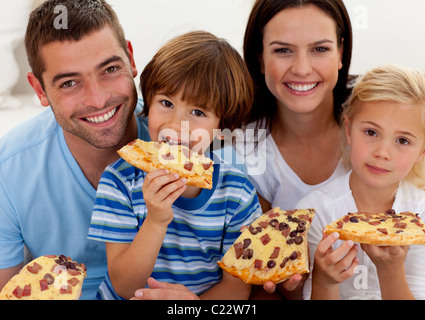 Porträt der Familie Essen Pizza im Wohnzimmer Stockfoto