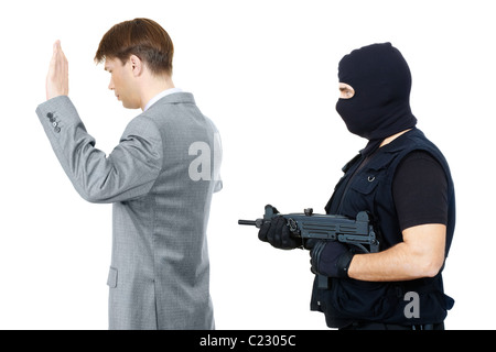 Opfer mit Handzeichen während der Mafia Vertreter zeigenden Waffe auf sie hinter Stockfoto