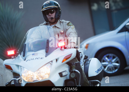 Patrouille Offizier sitzt auf dem Motorrad mit Hazrd Lichtern beleuchtet Stockfoto