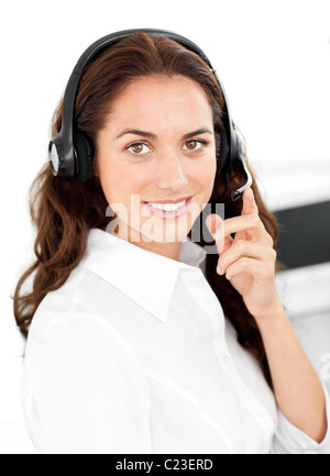 Positive Frau mit Kopfhörer arbeitet in einem Callcenter Stockfoto