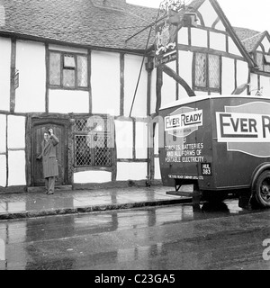 England der 1950er Jahre.  Verkäufer für die Firma jemals bereit Batterie winkt die Kamera wie er im alten Kings Arms Pub nennt. Stockfoto