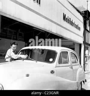 England, 1950er Jahre. Foto von J Allan Cash von einem Tankwart Reinigung der Frontscheibe eines Autos an einer Tankstelle Mobilgas Stockfoto