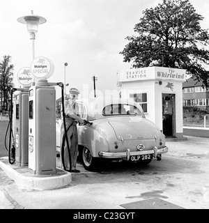 1950s, historisch, ein uniformierte Pumpenwart, der an einer Mobilgas-Tankstelle, The Whirlwind, England, ein Auto in Austin mit Benzin befüllt. Stockfoto