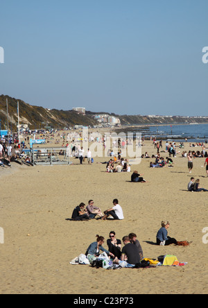 Menschen entspannen im Frühjahr am Strand von Bournemouth Stockfoto