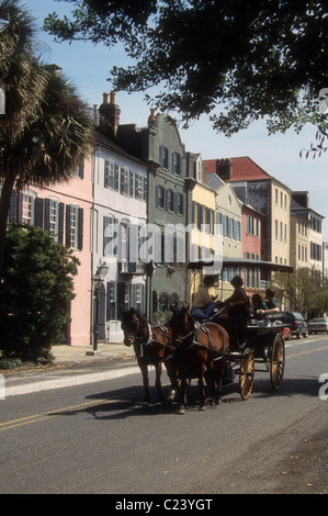 Touristen in Pferd gezogen Carrriage Ansicht der berühmte und historische Rainbow Row in Charleston, SC. Stockfoto