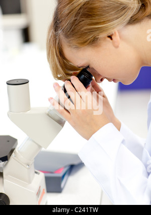 Konzentrierte Wissenschaftlerin Blick durch ein Mikroskop Stockfoto